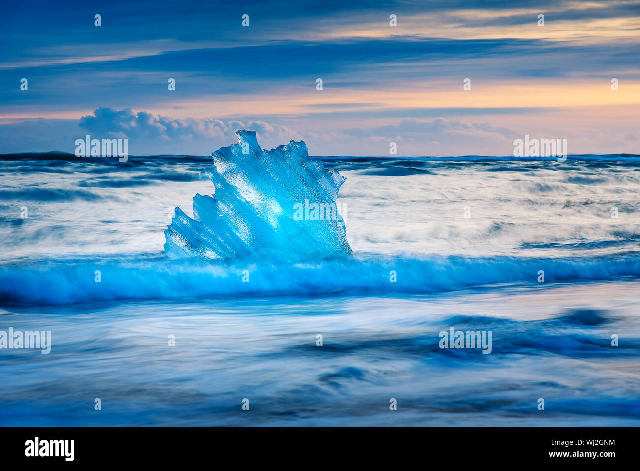 Eisberg Stücke von Wellen auf Diamond Beach in Island gewaschen bei Sonnenuntergang Stockfoto