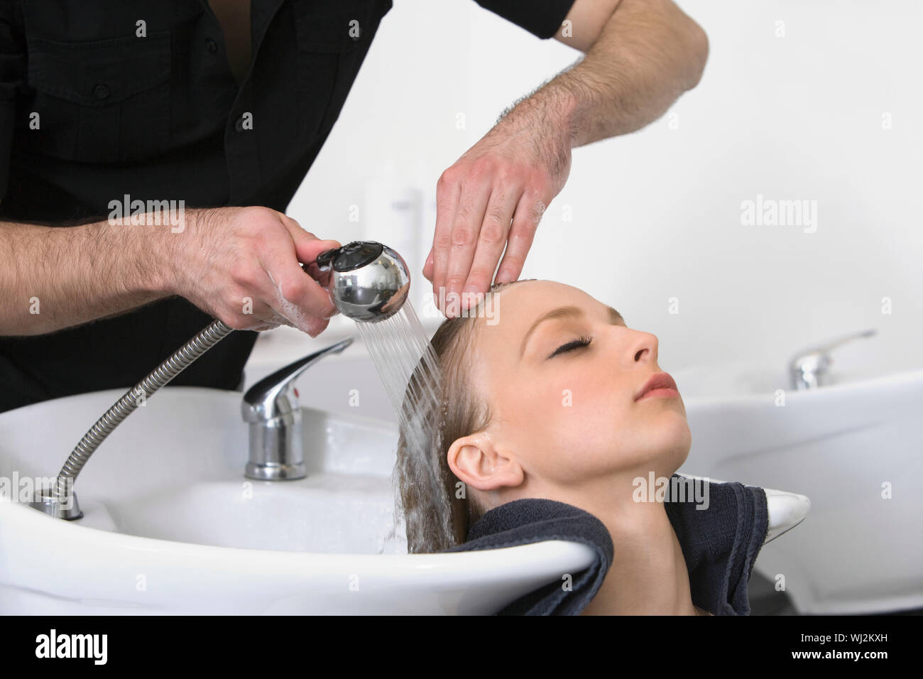 Nahaufnahme der jungen Frau, Haare waschen von Friseur im Salon Stockfoto