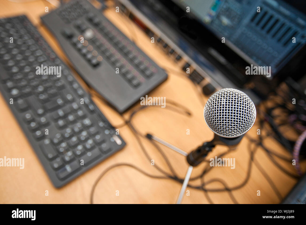 Mikrofon und Computer-Tastaturen auf Tisch im Fernsehstudio Stockfoto