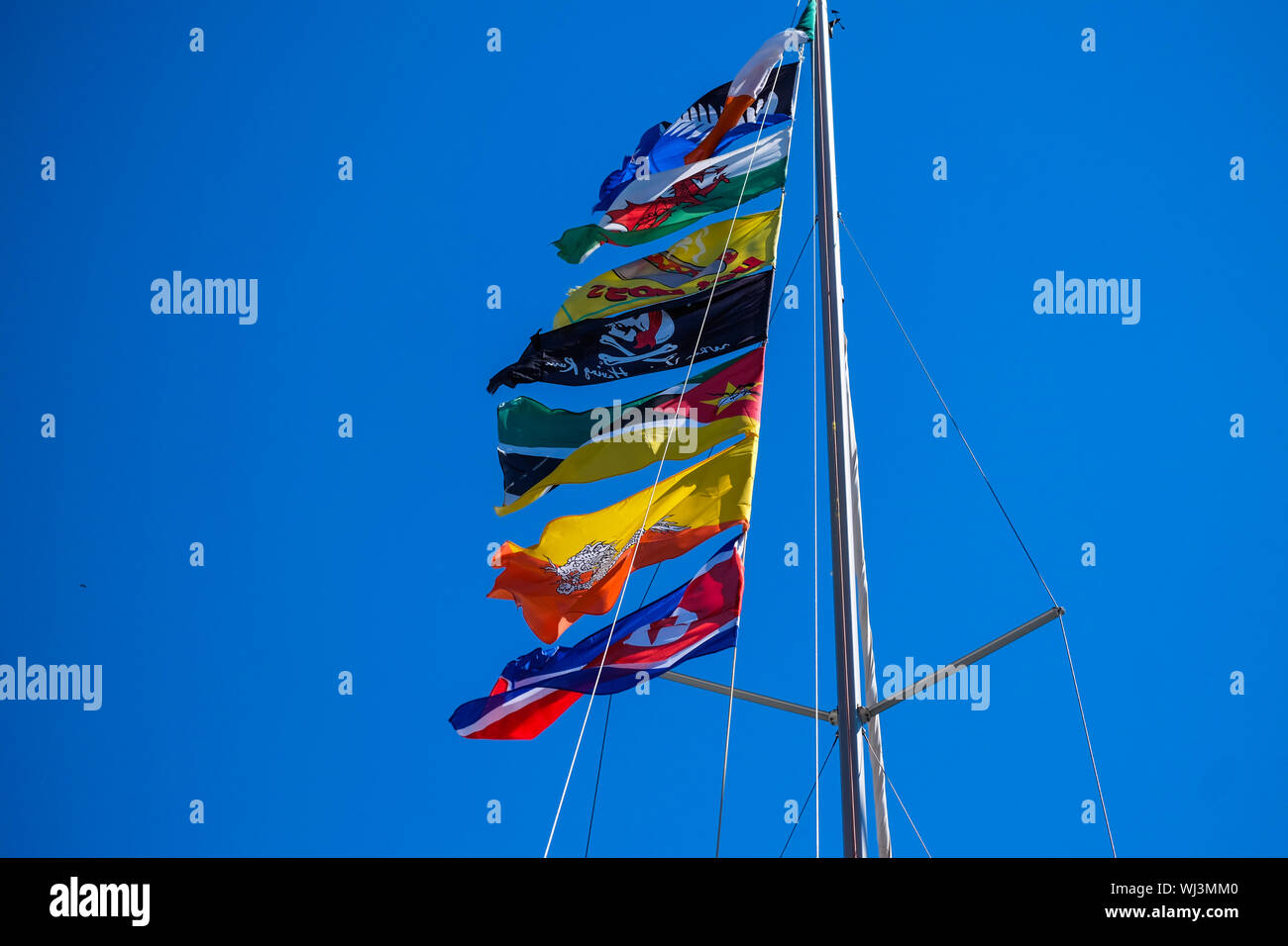 Sammlung von Flaggen auf einem Segelboot mit einem schönen blauen Himmel Hintergrund Stockfoto