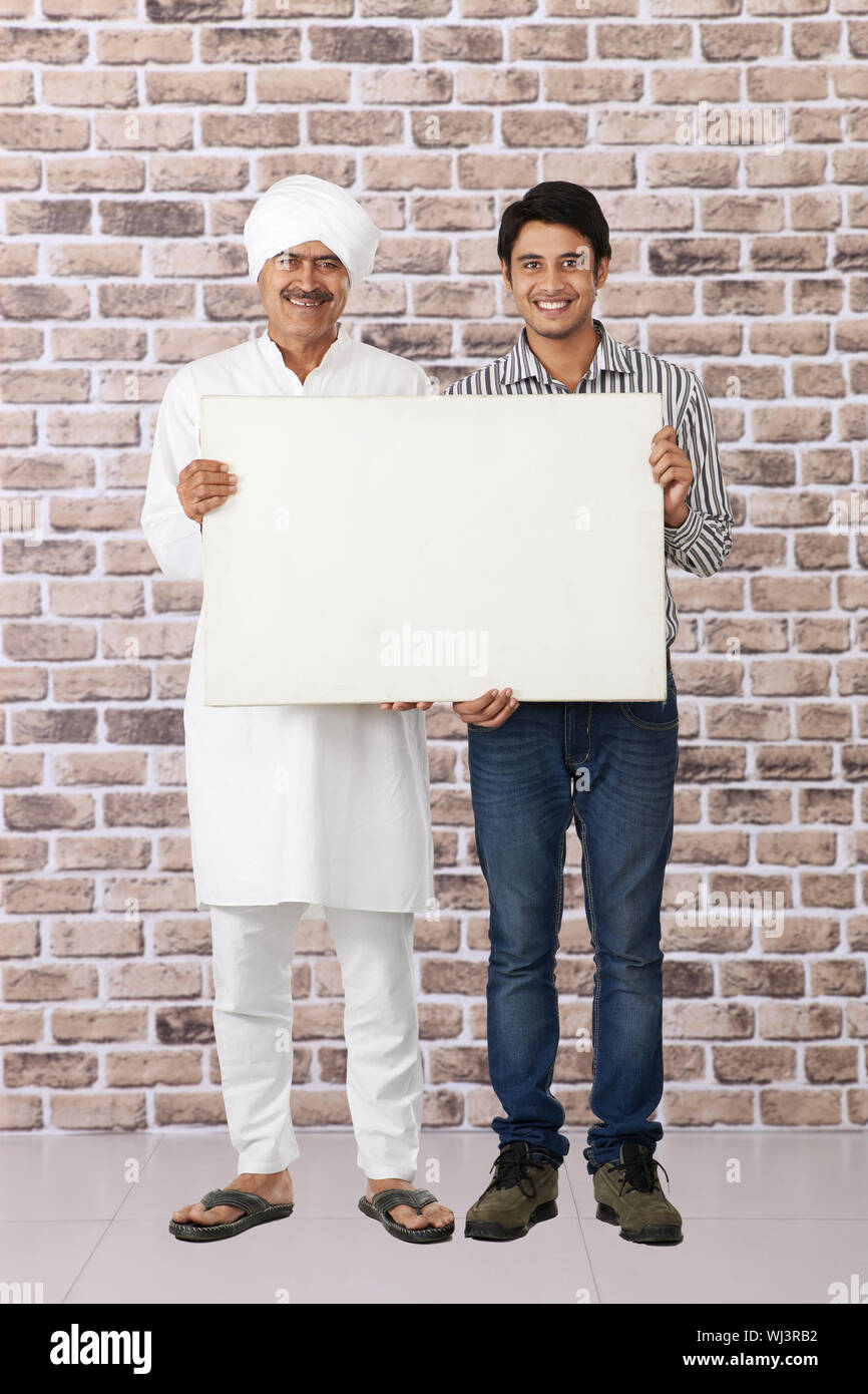 Der alte Mann steht mit seinem Sohn und zeigt ein Plakat Stockfoto