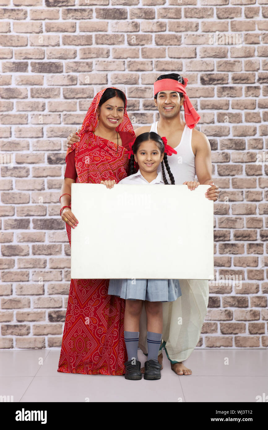 Ländliche Familie zeigt ein Plakat und lächelt Stockfoto