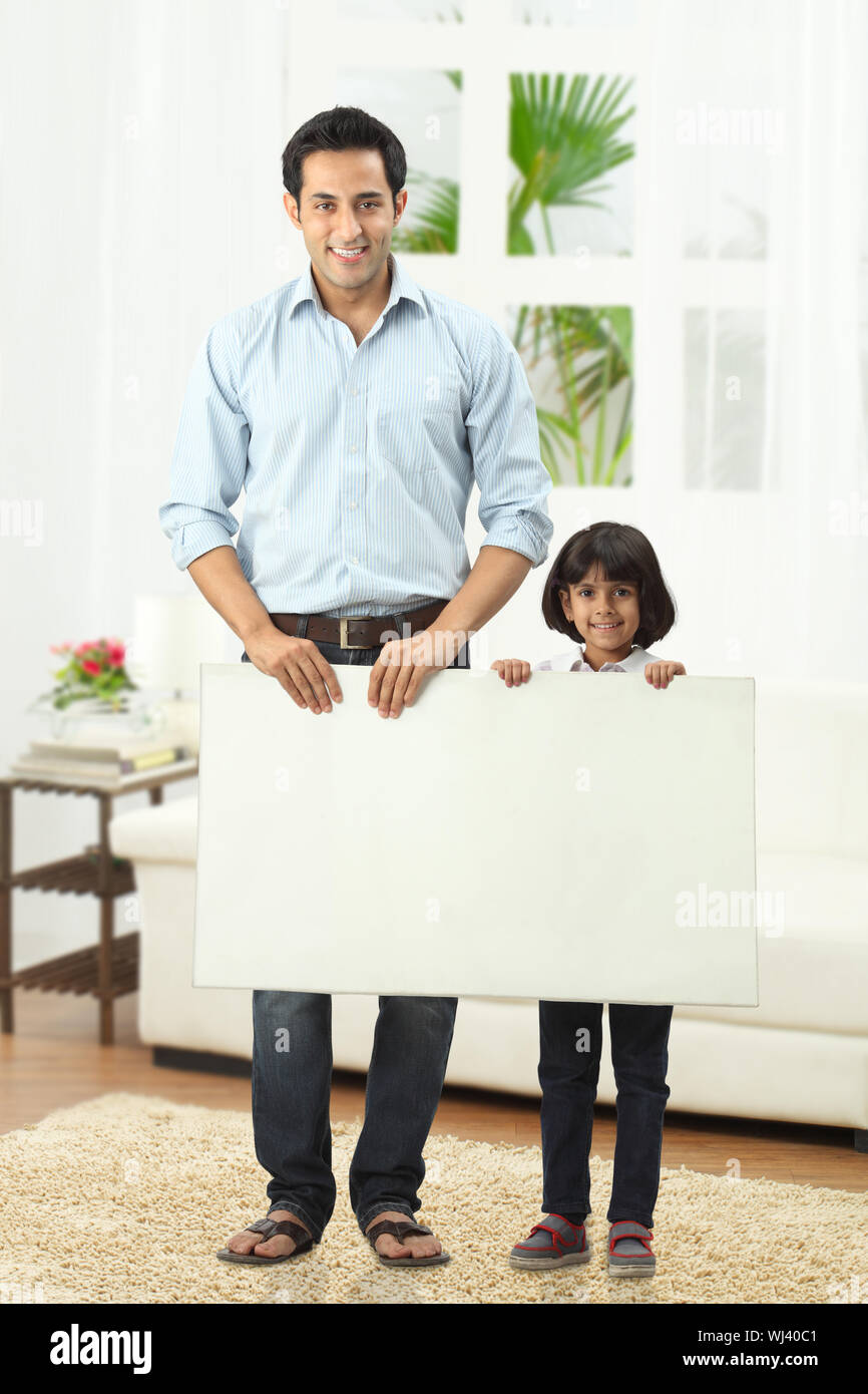 Vater mit Tochter, die zu Hause ein Plakat hält Stockfoto