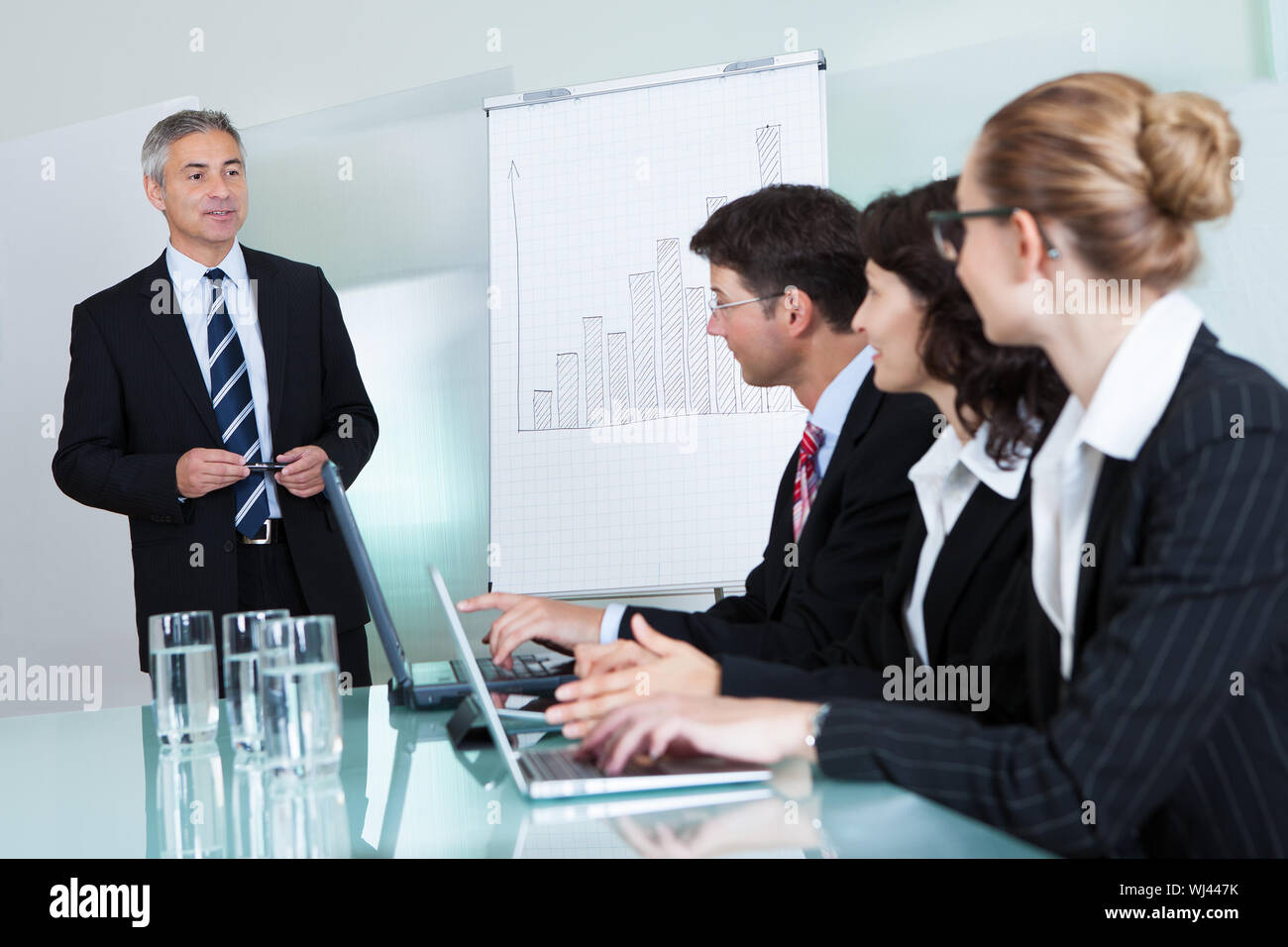 View-Bild aus einer Reihe von Geschäftsleuten auf Laptops und Tablets beschnitten während einer Präsentation oder Tagung Stockfoto