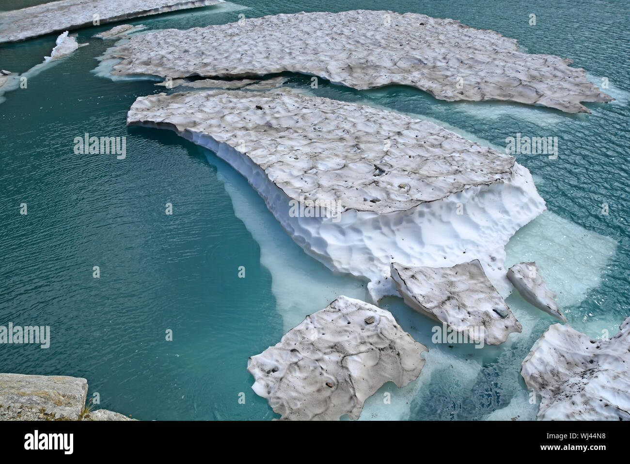Eisberge aus einem Gletscher gebrochen in einem Gletschersee auf die Berge wie das Klima erwärmt. Stockfoto