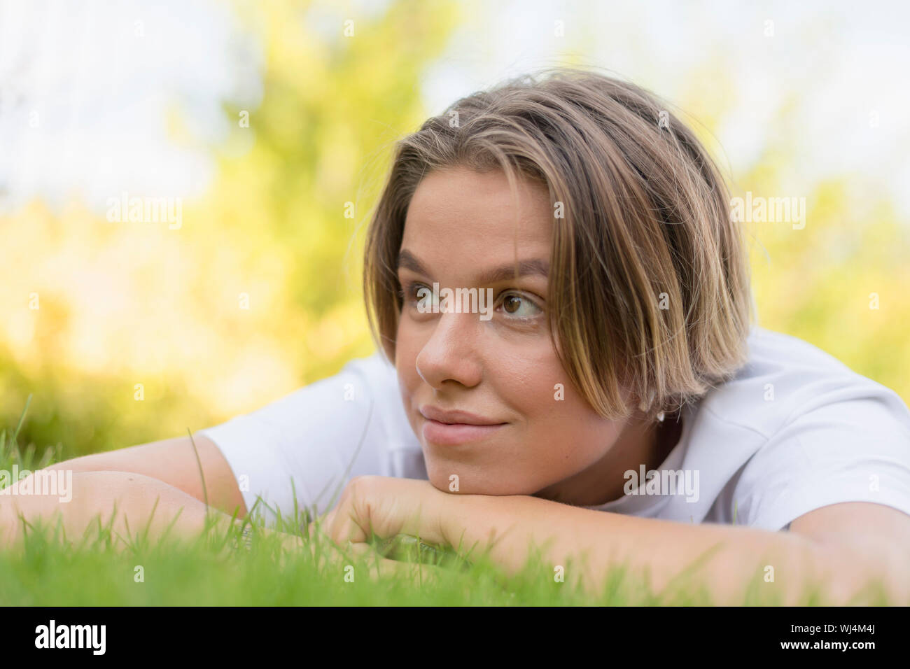 Junge Frau, die Verlegung in Rasen Stockfoto