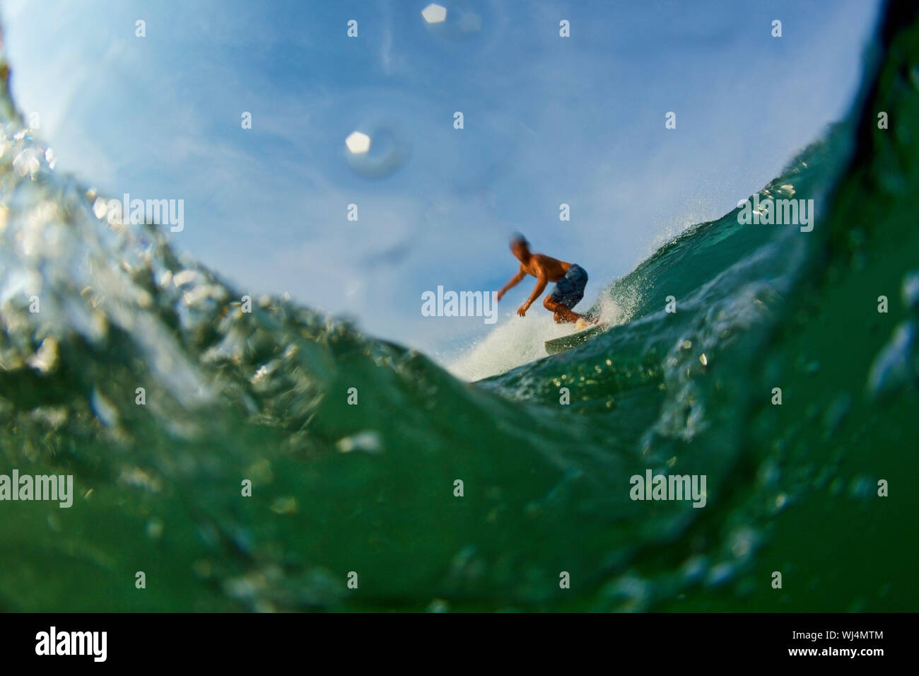 Männliche surfer reiten Ocean Wave Stockfoto