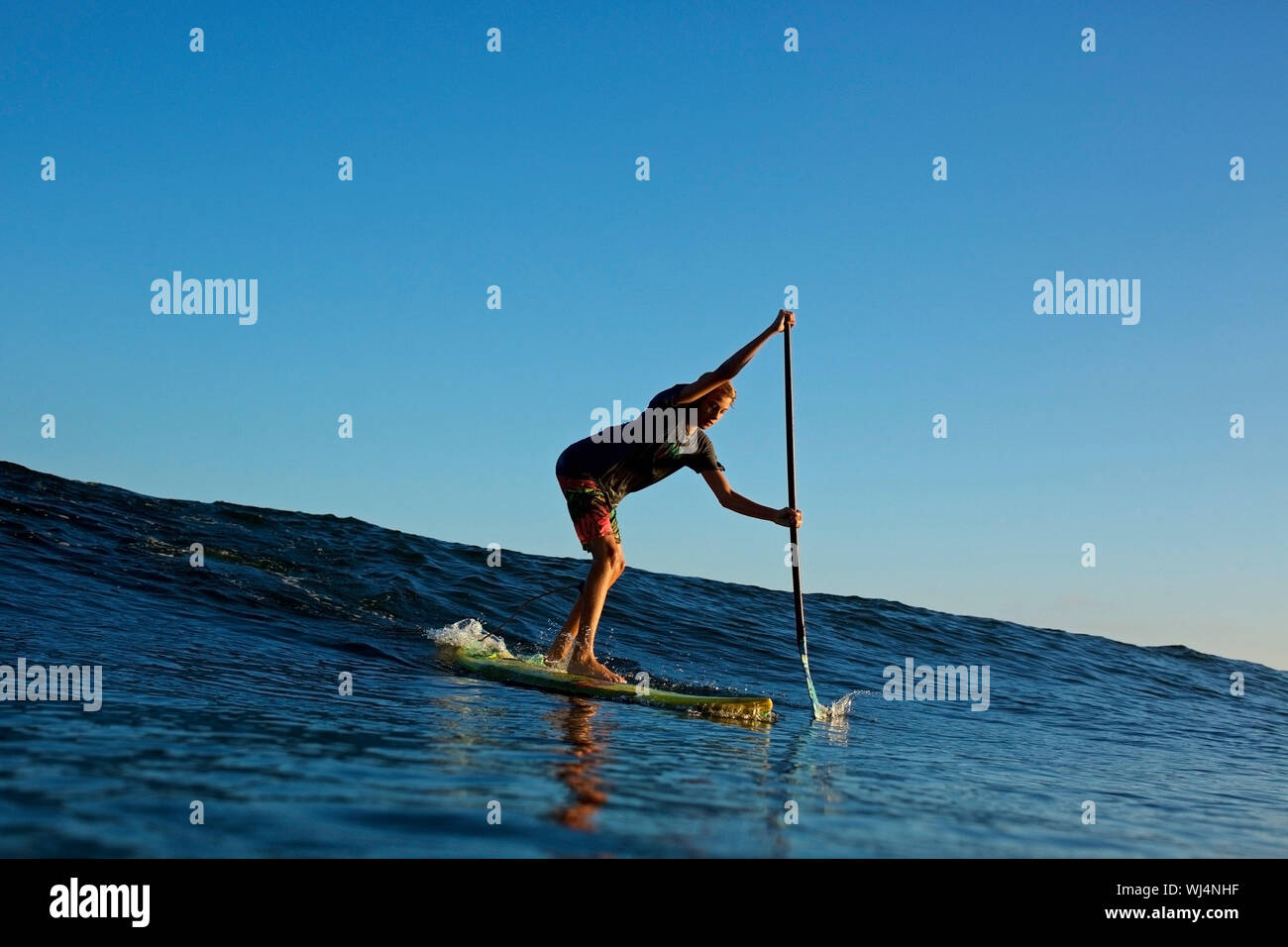 Paddel boarder reiten Ocean Wave Stockfoto