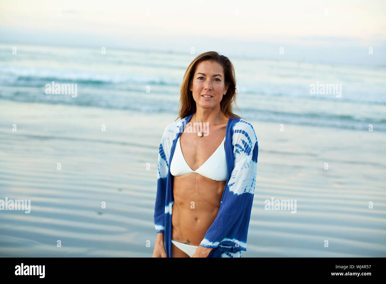 Portrait selbstbewusste Frau im Bikini am Ocean Beach Stockfoto