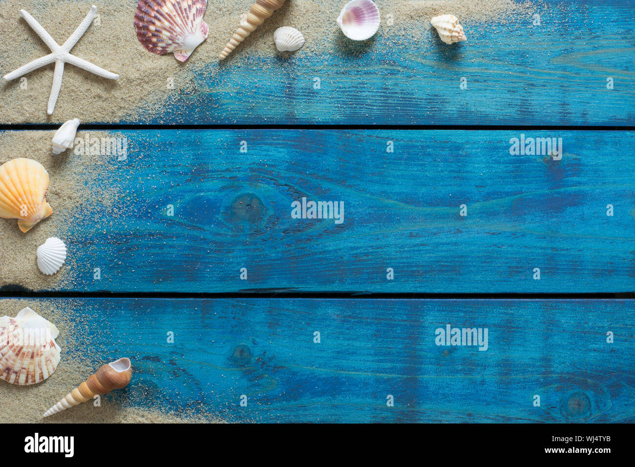Sommer Banner mit Muscheln, Seesterne und Sand auf Blau Holz- Hintergrund Stockfoto