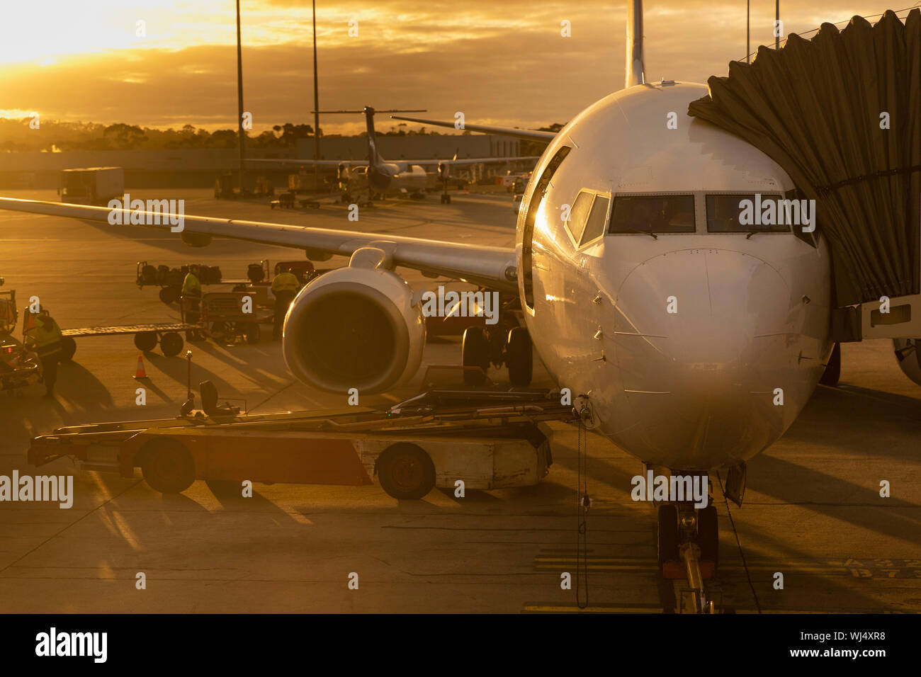 Commercial Airplane an Anschlußklemme auf Asphalt geparkt bei Sonnenuntergang Stockfoto