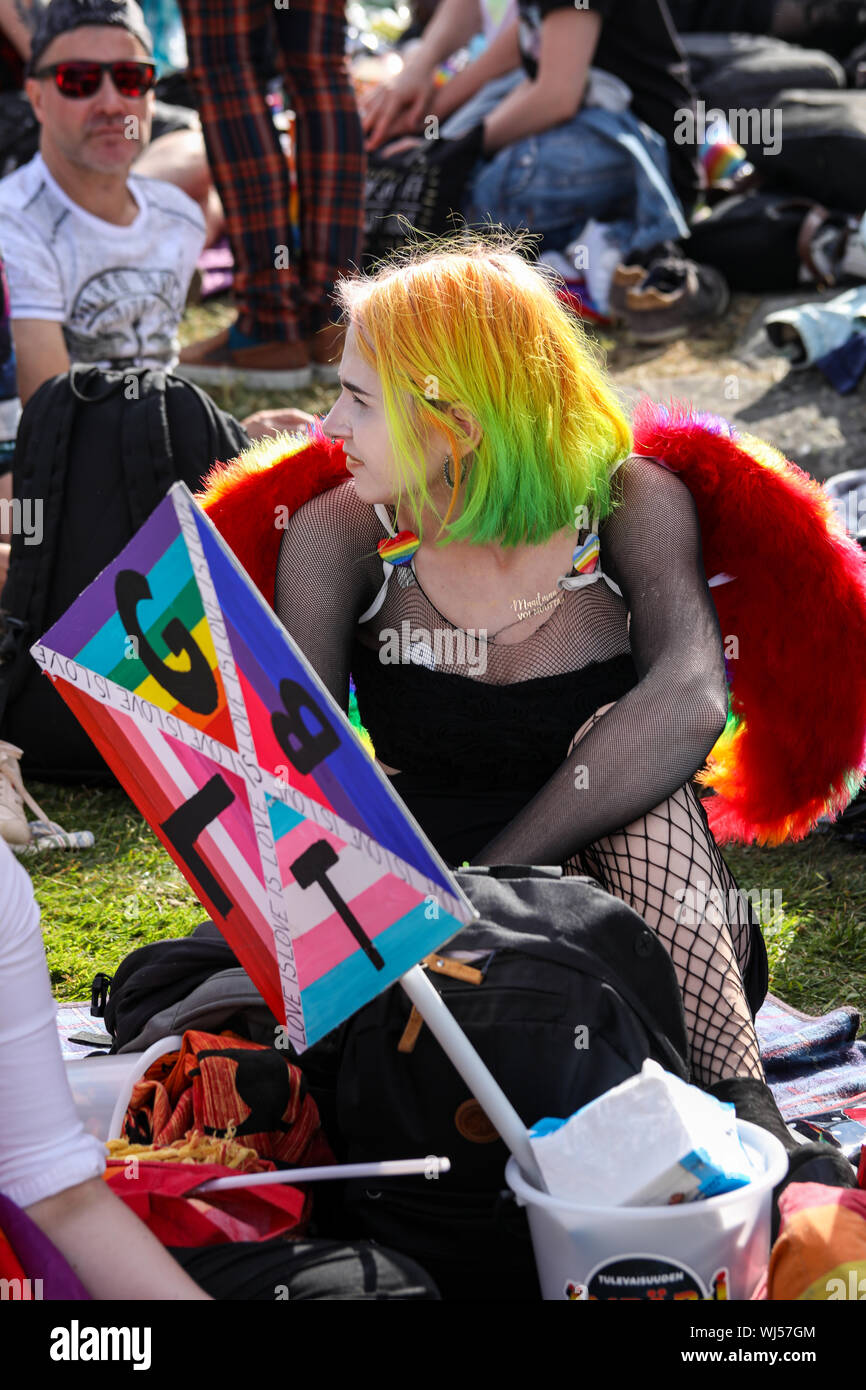 Junge Person mit LGBT-Zeichen in Helsinki Stolz nach - Partei in Kaivopuisto Park Stockfoto