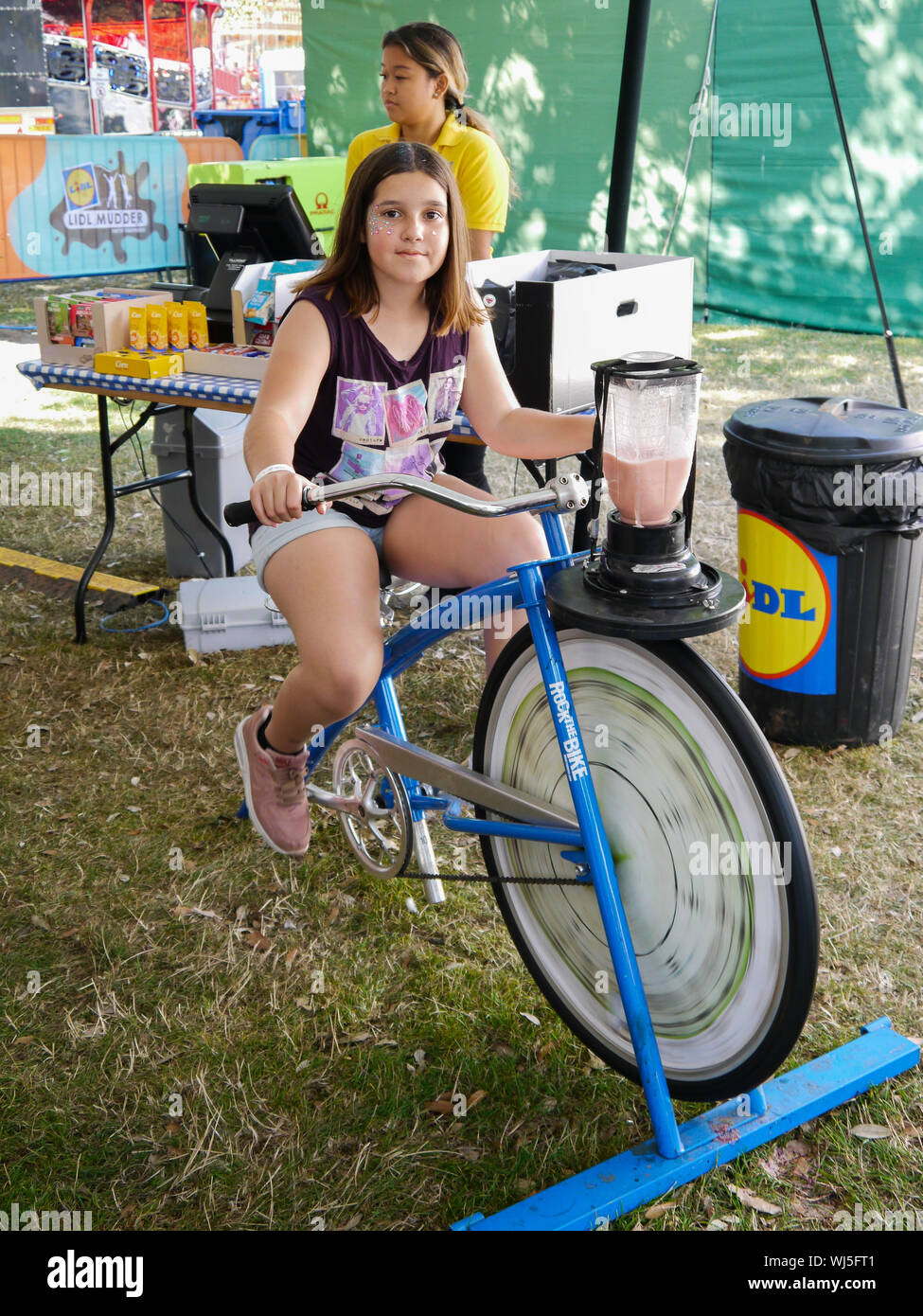 Ein junges Mädchen einen Smoothie mit einem stationären Fahrrad Stockfoto