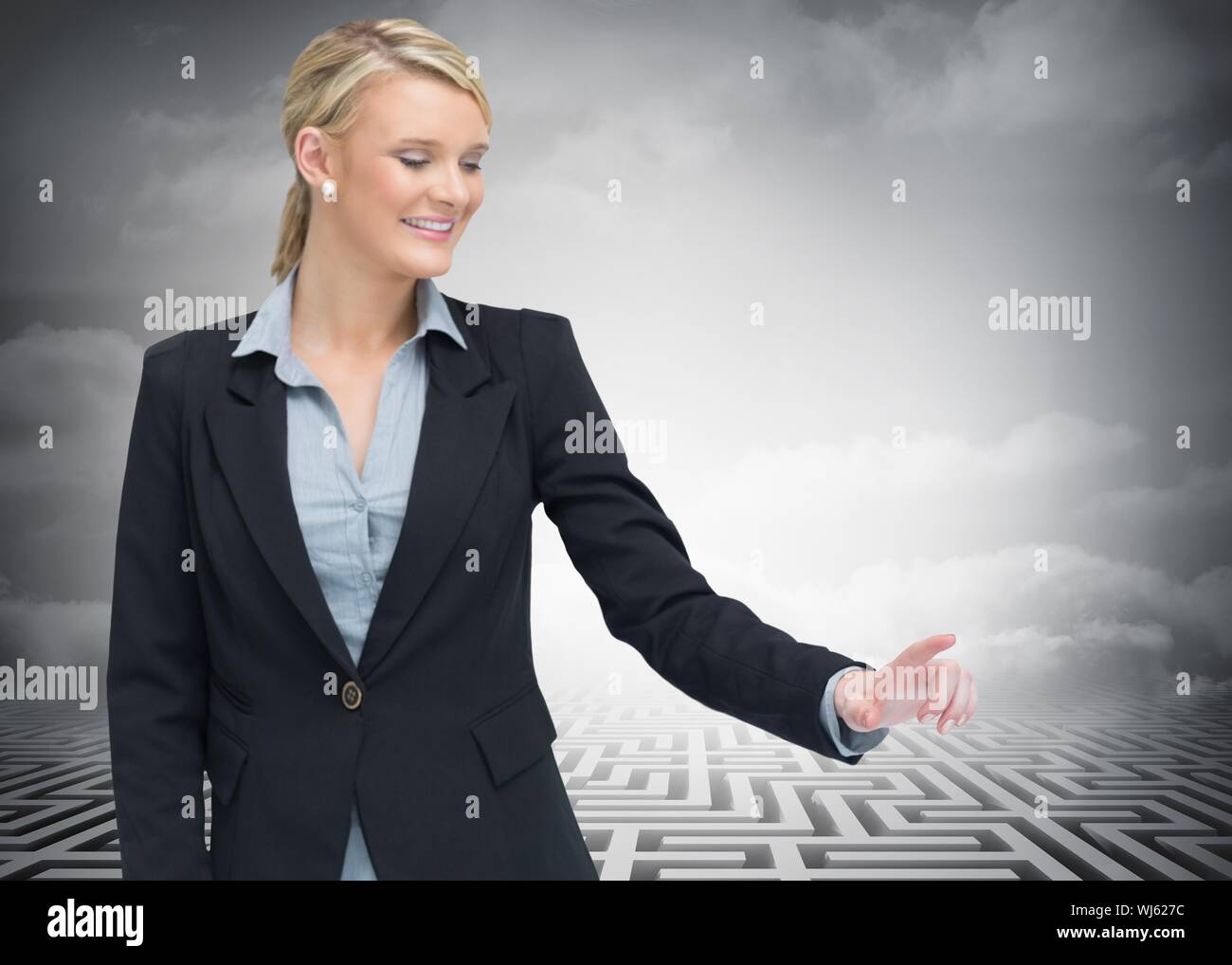 Das zusammengesetzte Bild von lächelnden Geschäftsfrau zeigen etwas, die vor riesigen Labyrinth im Hintergrund Stockfoto
