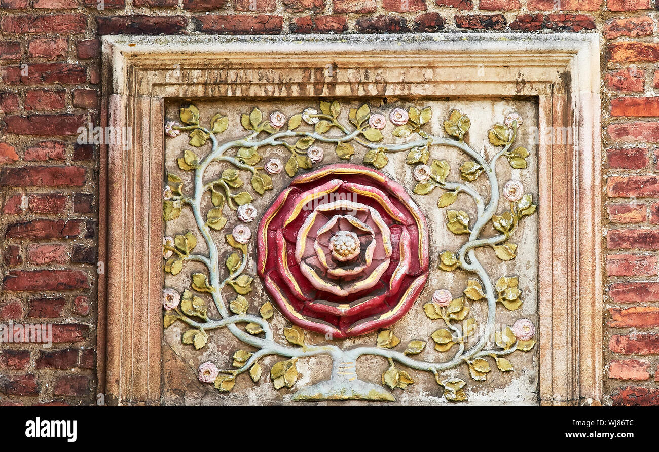 Turso rote Rose Design an einer Wand an der Hochschule von St. John, Universität Cambridge, England. Stockfoto