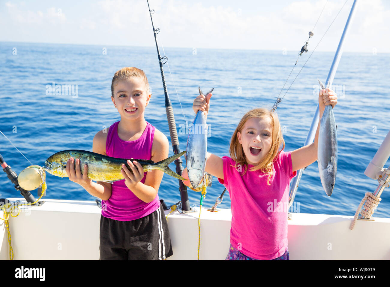 Glücklich Thunfisch Fischerinnen Kind Mädchen auf Boot mit Fische fangen mit Dorado trolling Mahi Stockfoto