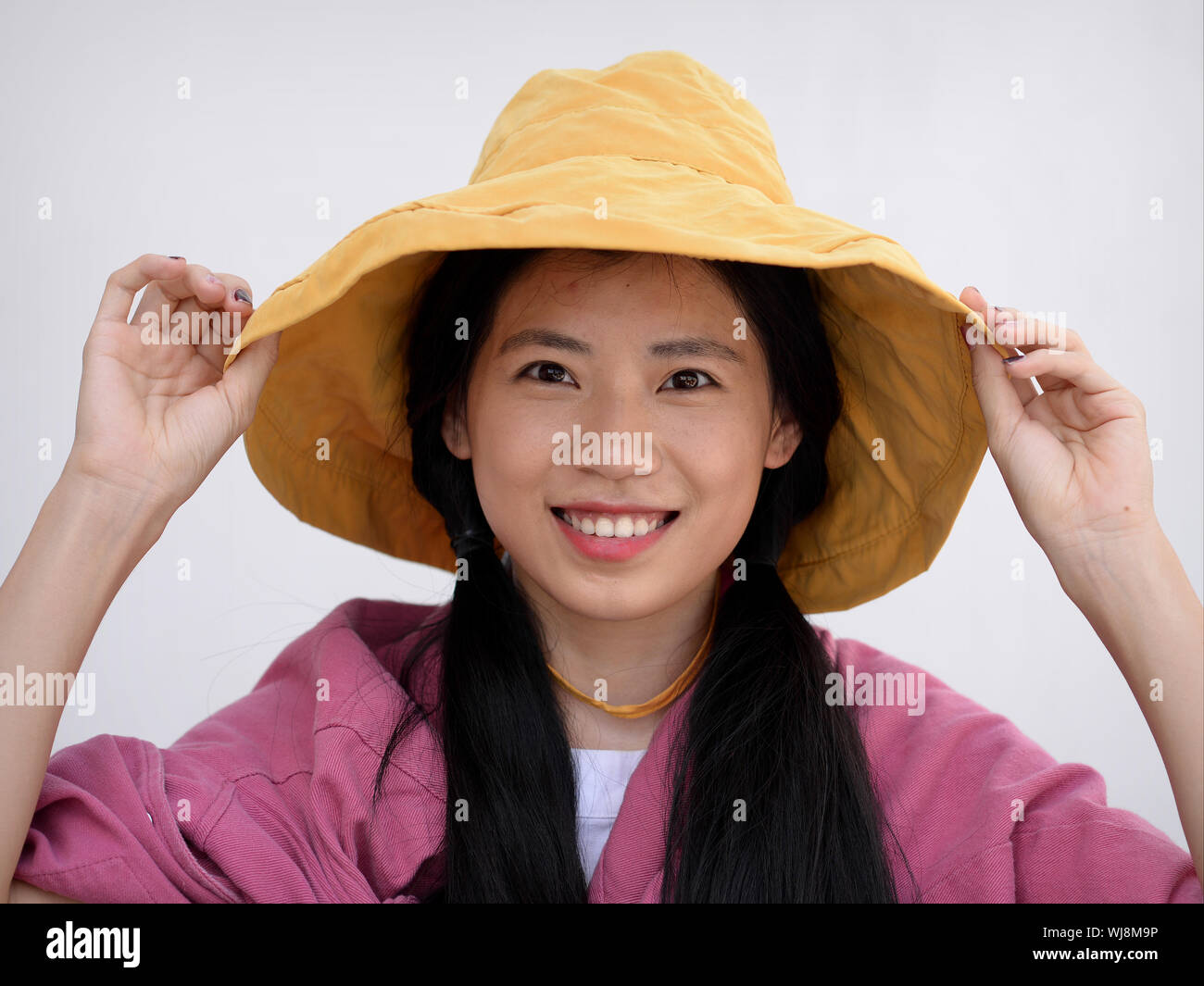 Hübsche Thai Girl posiert für die Kamera mit einem gelben Diskette hat. Stockfoto