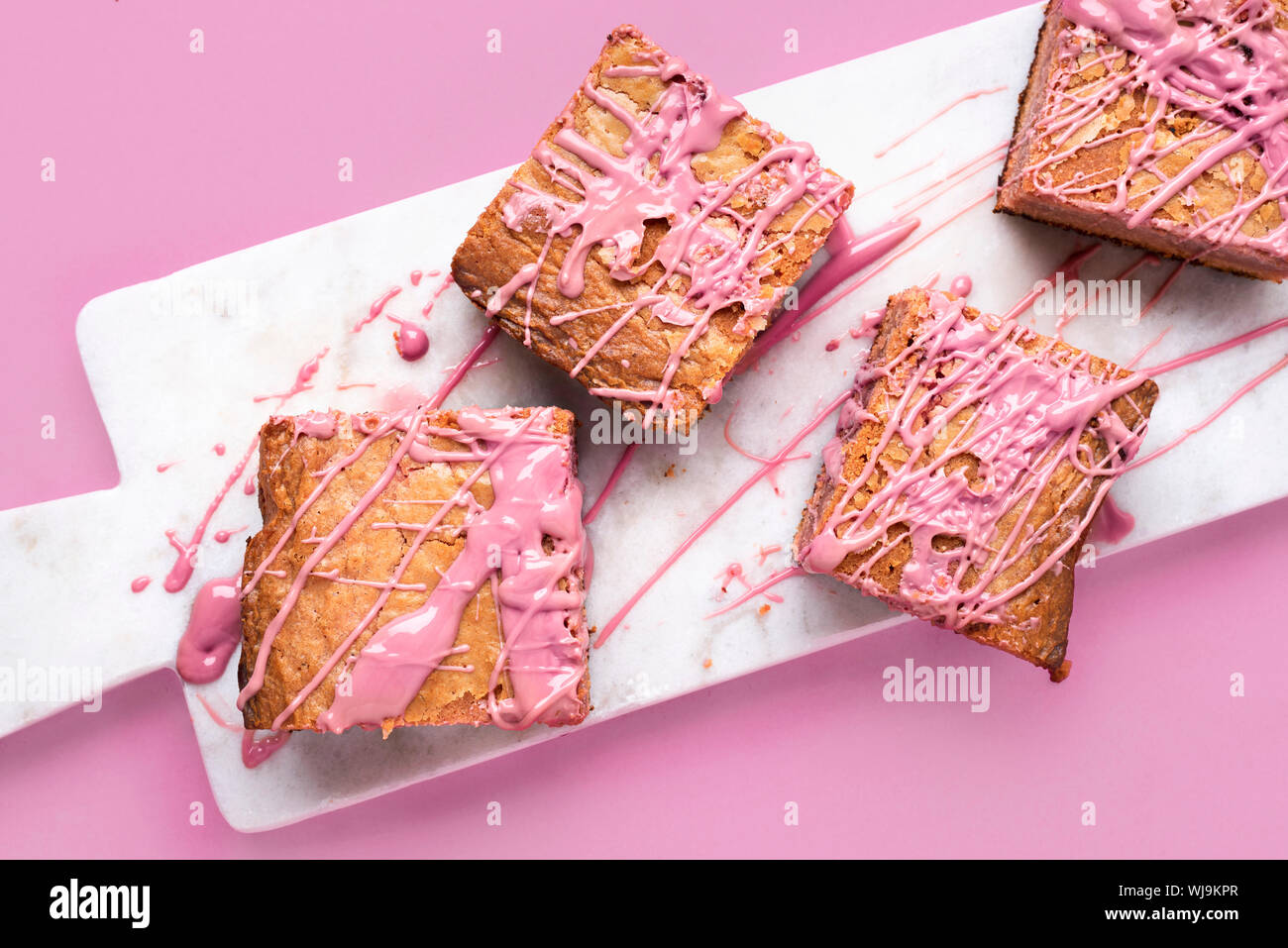 Rosa Brownies mit Ruby Schokolade auf weißem Marmor Schneidbrett und rosa Hintergrund. Close-up-Bild von ruby Schokolade Kuchen. Oben Ansicht von rosa Süßigkeiten Stockfoto