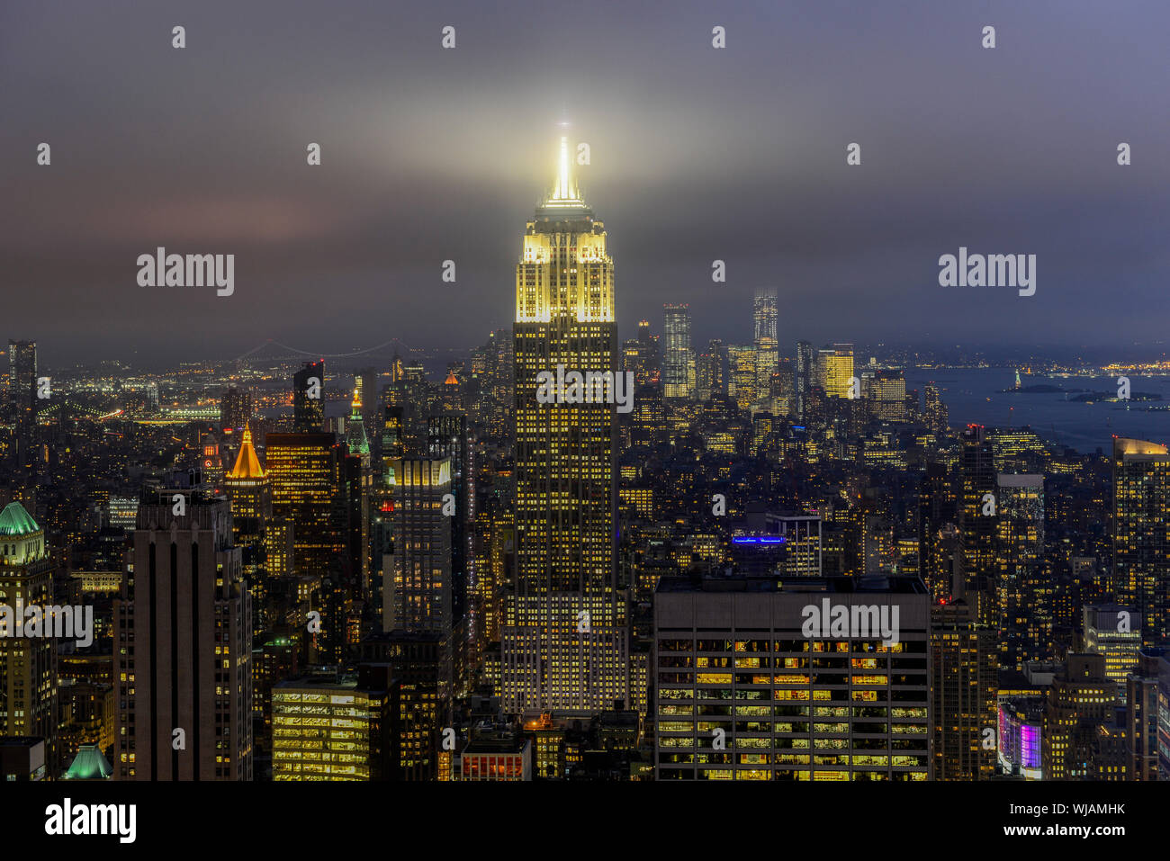 USA, New York City, Manhattan Skyline mit Blick auf das Empire State Building am Abend, vom Rockefeller Center, oben auf dem Felsen Stockfoto