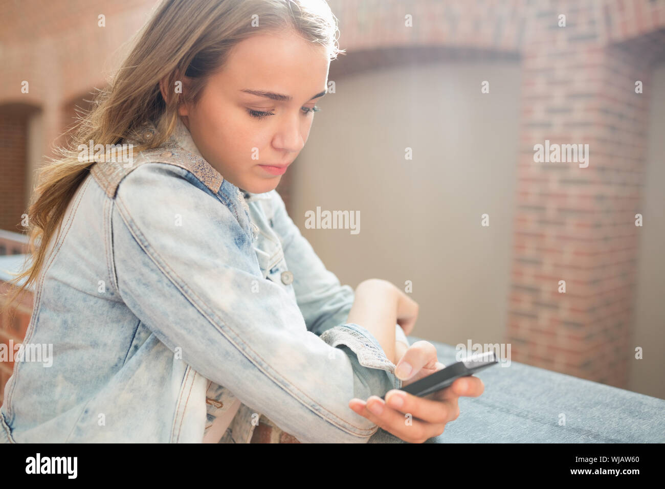 Ernsthaften Studenten stehen in der Halle eine SMS Stockfoto