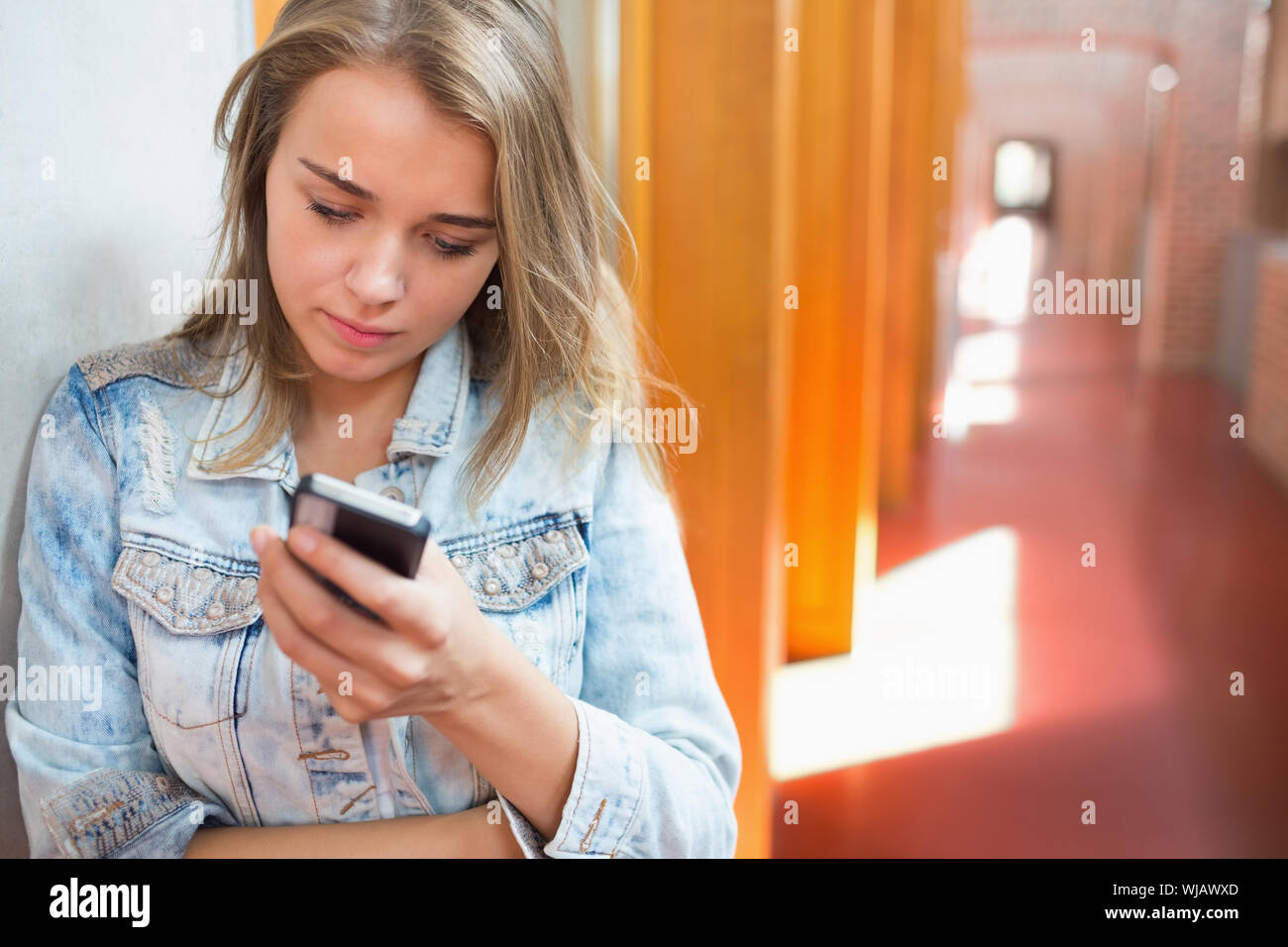 Hübsche Studentin stehen in der Halle eine SMS Stockfoto