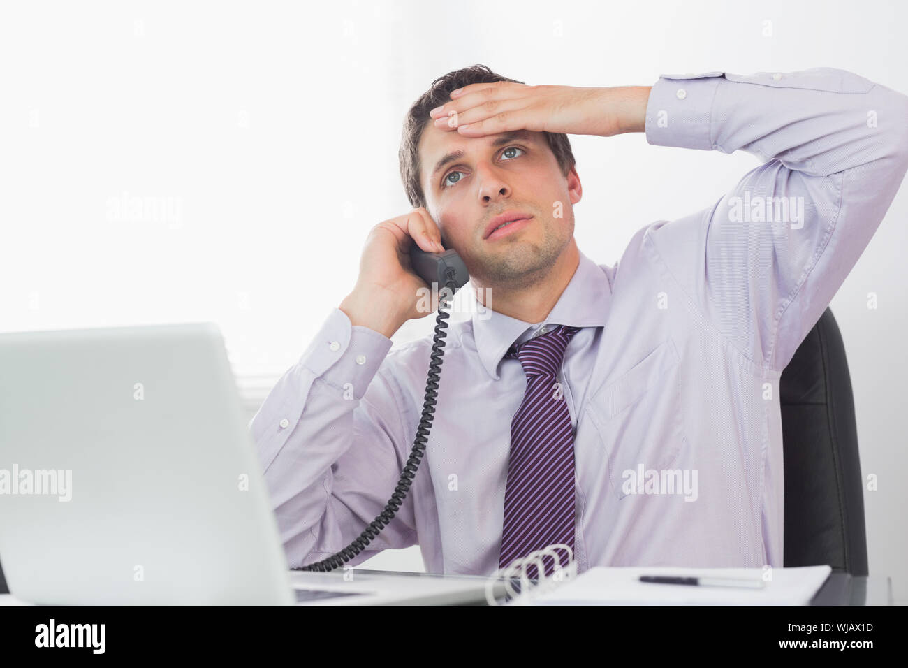 Besorgt Geschäftsmann auf Anruf an der Rezeption Stockfoto