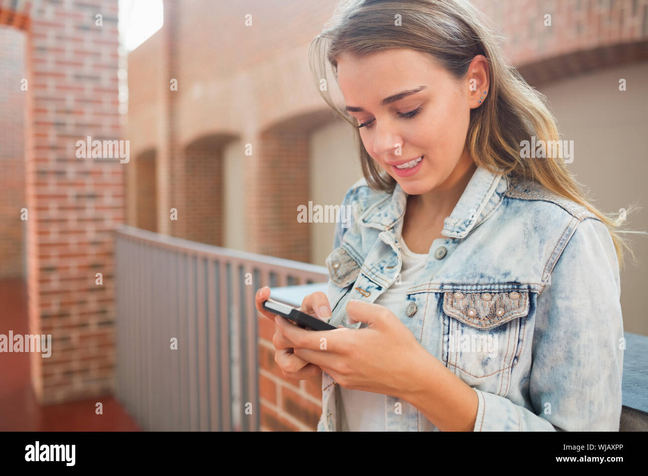 Lächelnd Schüler stehen in der Halle eine SMS Stockfoto