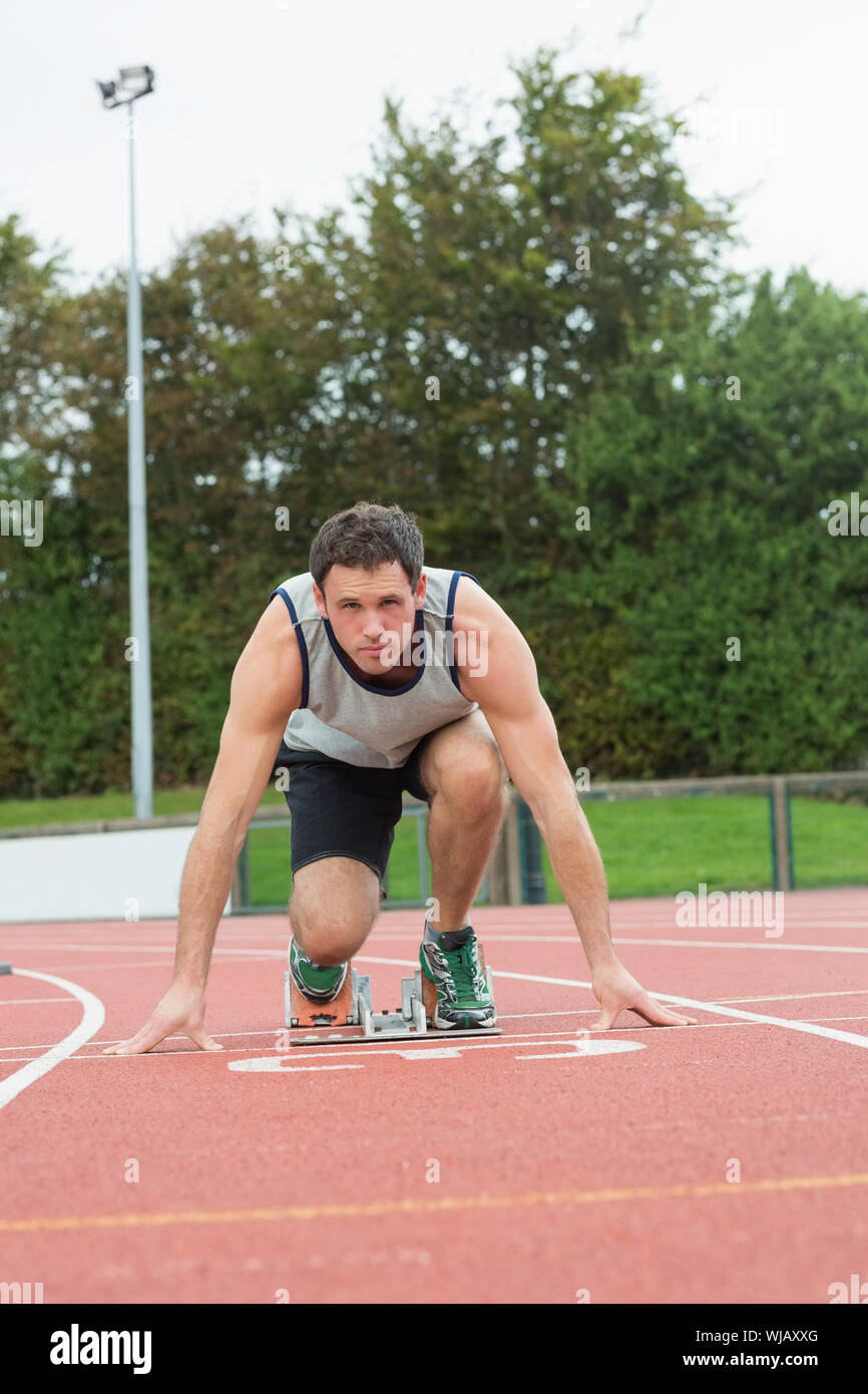 Junger Mann bereit für das Rennen auf der Laufstrecke Stockfoto