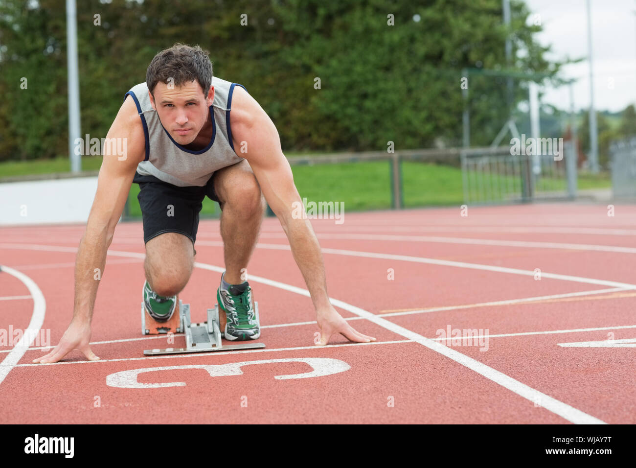 Junger Mann bereit für das Rennen auf der Laufstrecke Stockfoto