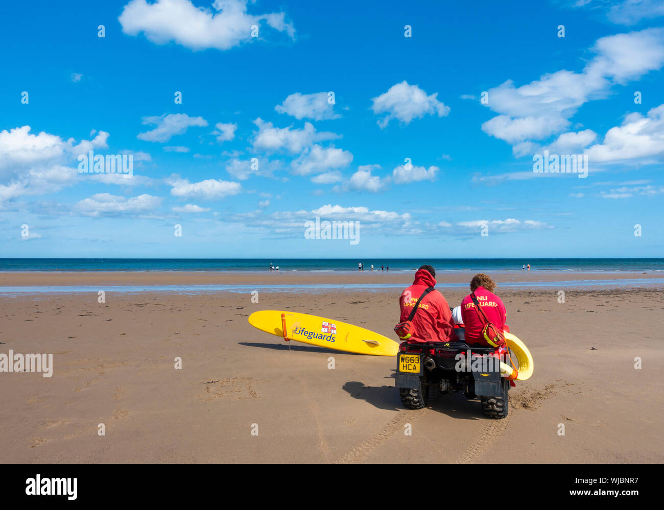 Ansicht der Rückseite zwei rnli Lifeguards sitzen auf dem Quad Stockfoto