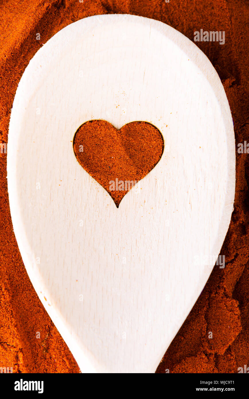 Herzform aus Spice auf einem Löffel aus Holz. Zusammensetzung. Stockfoto