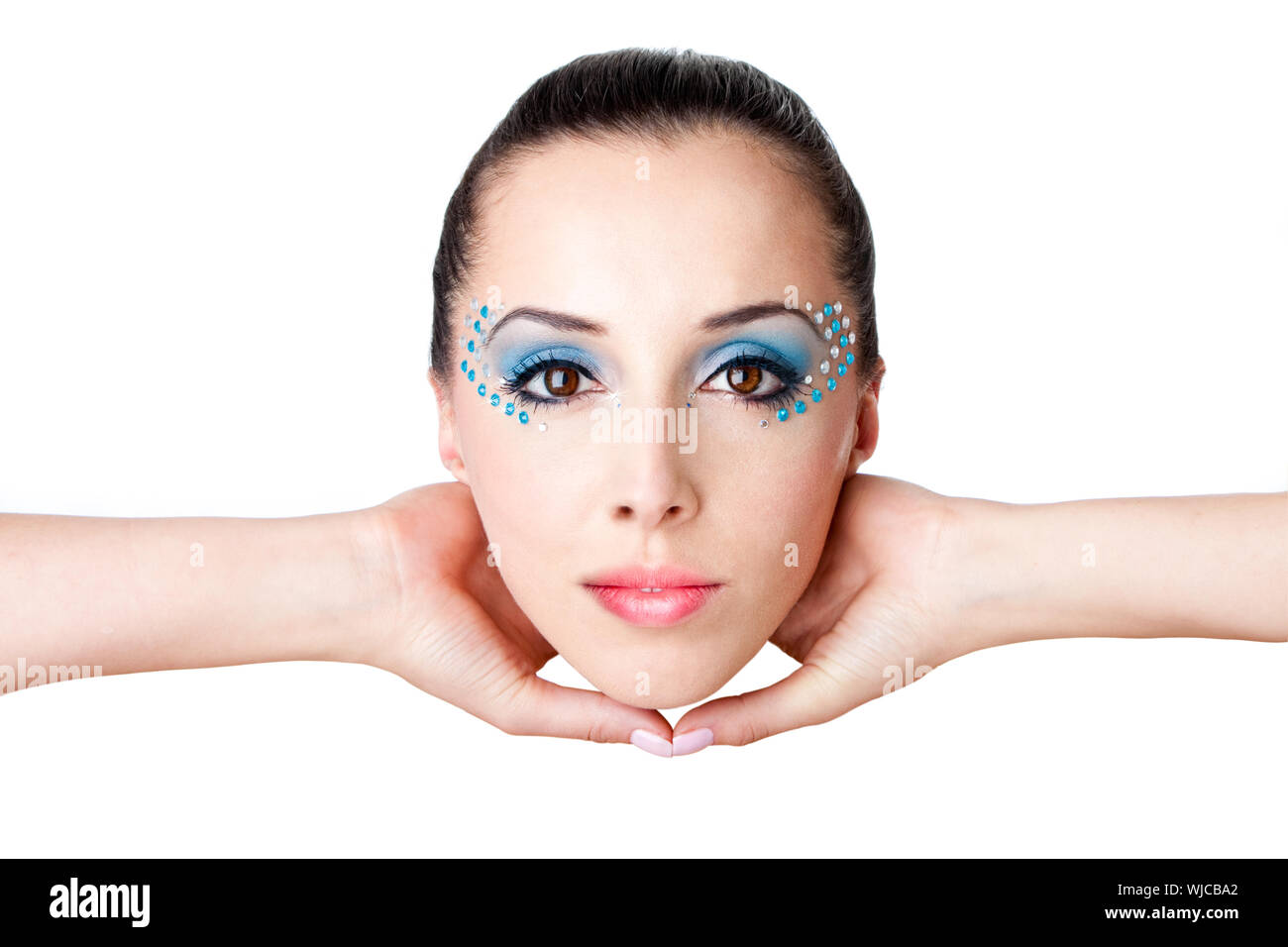 Schöne weibliche Mode Gesicht mit blauen Make-up und Edelsteine Strass von einem kaukasischen Hispanic Frau mit Händen in der Luft gehalten, isoliert. Stockfoto