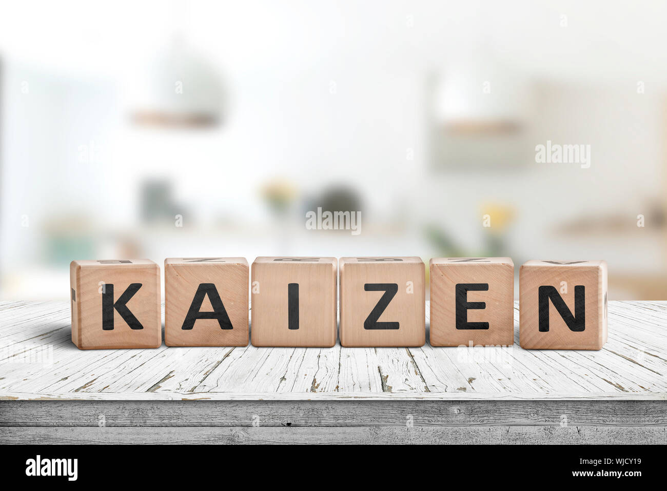 Kaizen Verbesserung Zeichen aus Blöcke auf einem hölzernen Schreibtisch in einem hellen Zimmer Stockfoto