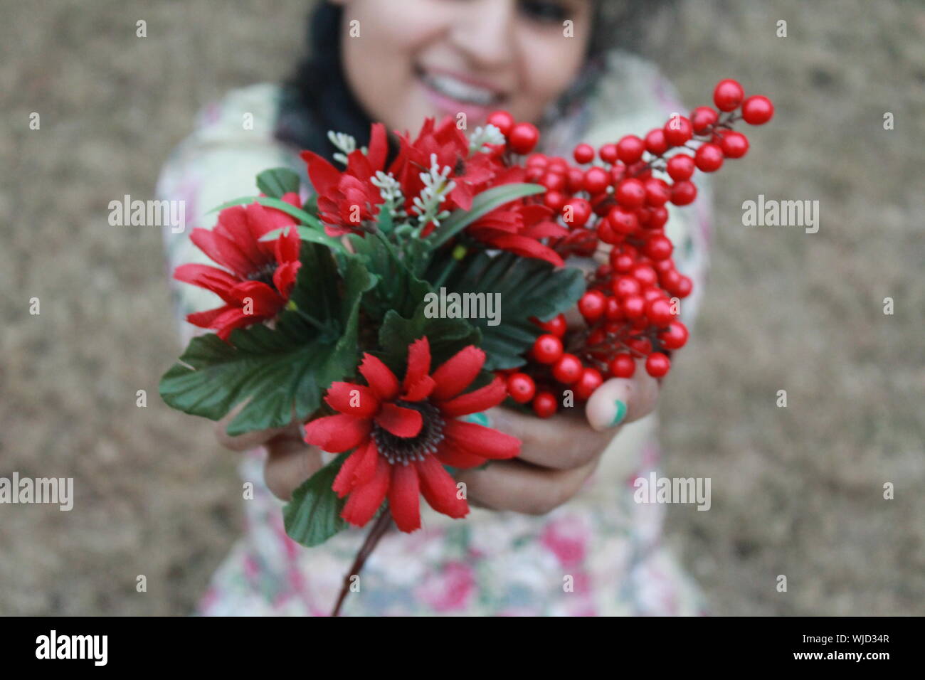 Close-up Porträt einer Frau mit roten Blumen Stockfoto