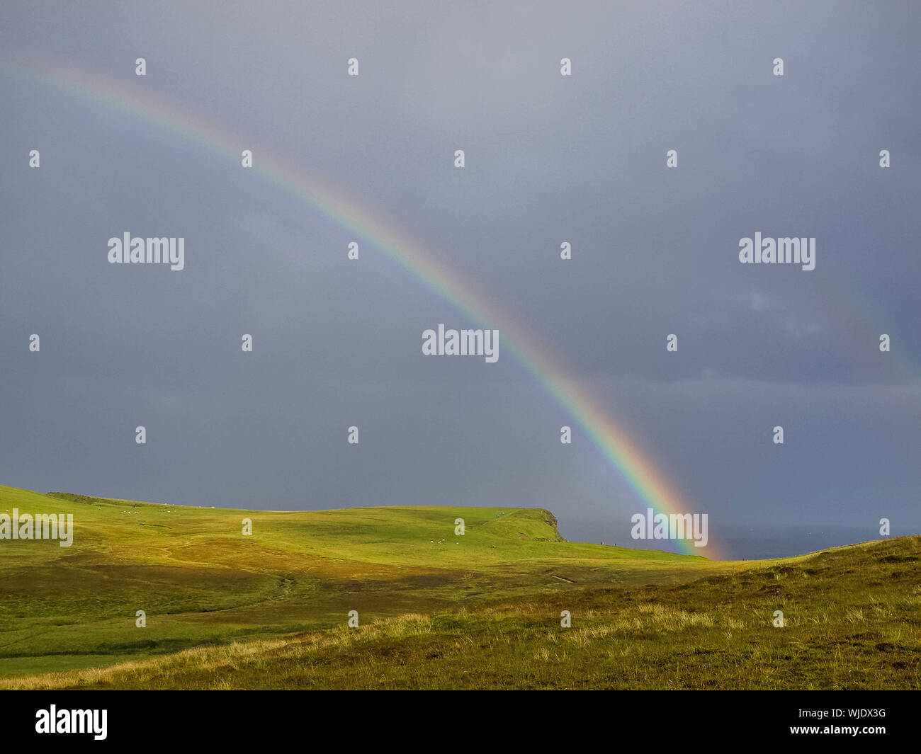 Riesige Regenbogen über Duncansby Head auf der nördlichen schottischen Küste Stockfoto