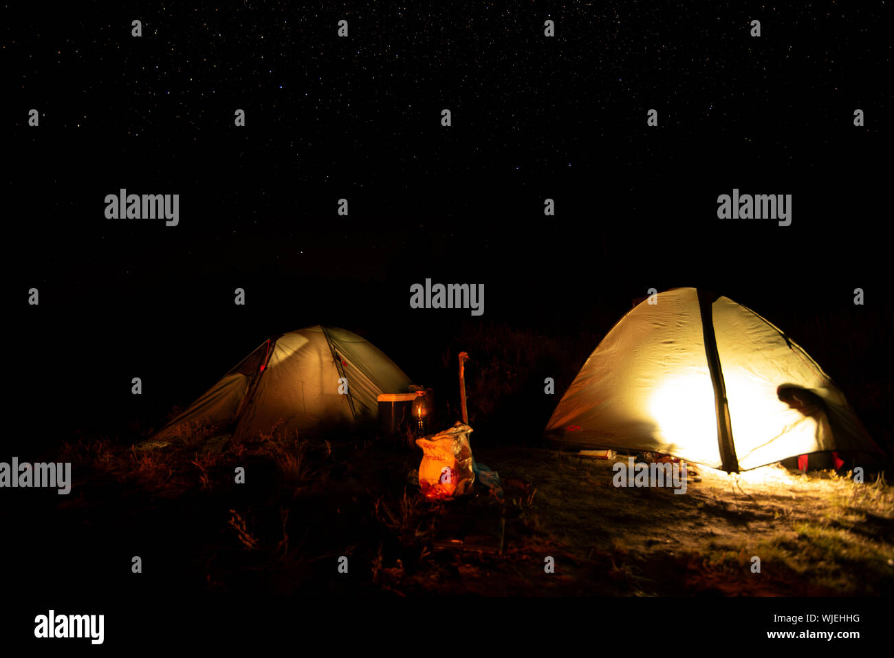 Abenteuer Romantik Nacht und Dämmerung in einem Zelt auf einer sternenklaren Nacht hoch in den Bergen vor der Morgendämmerung Stockfoto