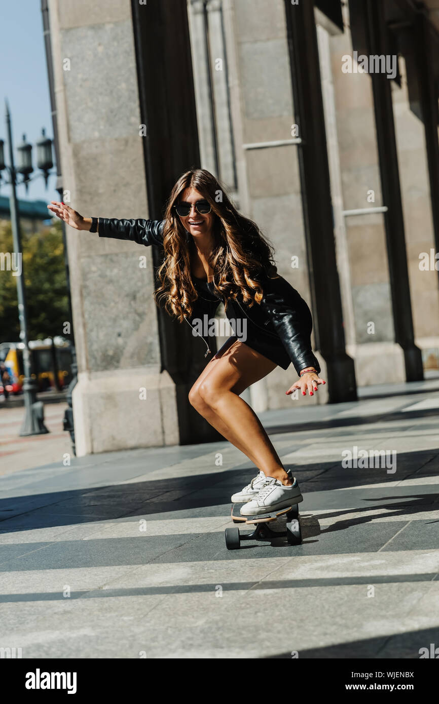 Schöne junge Skater Frau reiten auf dem Longboard in der Stadt. Stilvolle  Mädchen in der Straße Kleidung reitet auf einem longboard. Skateboard,  Straße Foto, Leben Stockfotografie - Alamy