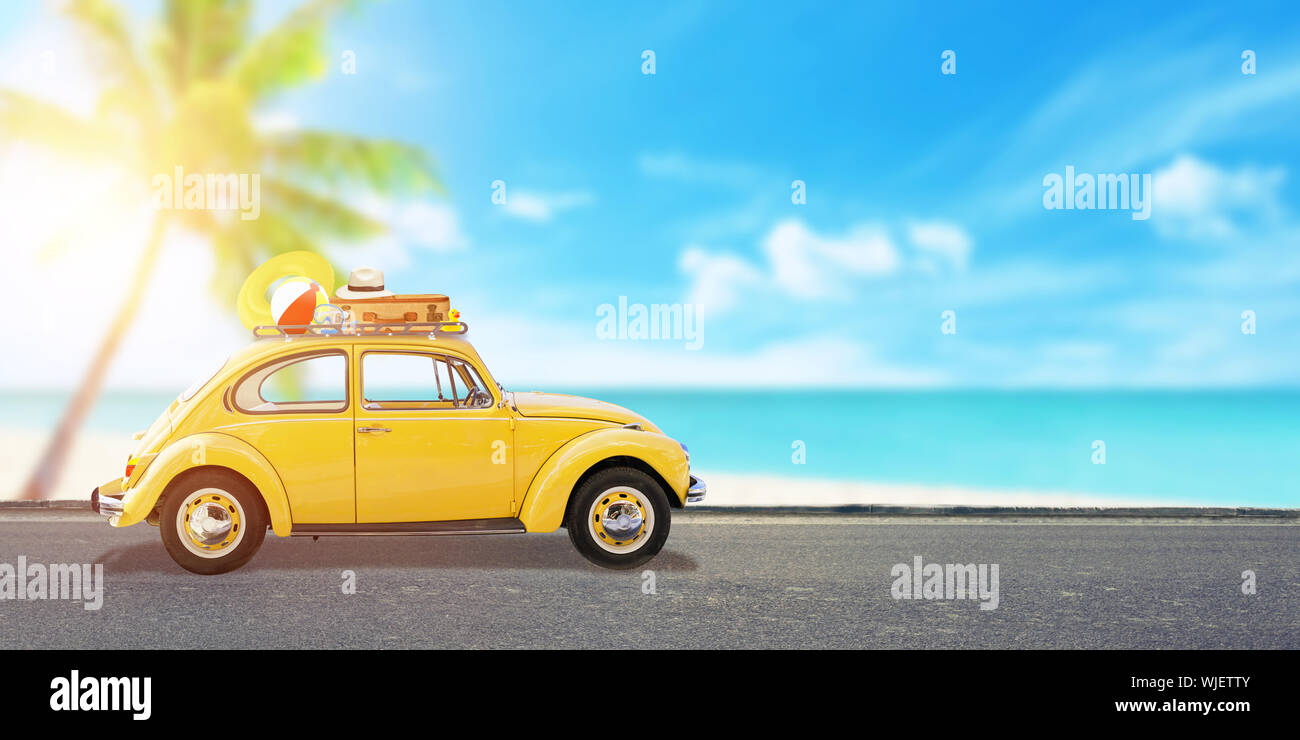 Sommer reisen Konzept mit gelben Old Timer auf der Straße und am Strand im Hintergrund. Kopieren Sie Platz neben. Stockfoto
