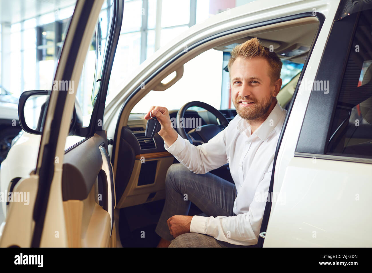 Auto Käufer Mann mit Schlüssel in der Hand in ein neues Auto in Auto Salon. Stockfoto