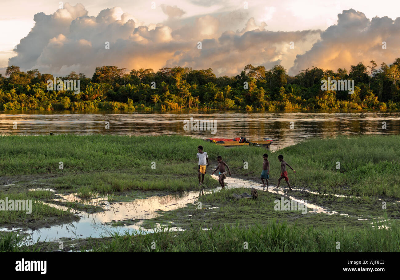 Neuguinea, Indonesien - Juni 26: Unbekannt Kinder spielen am Ufer des Flusses, in der Nähe des Dorfes. Rückgang, am Ende des Tages. Juni 26, 2012 in Dorf, Neu Guinea Stockfoto