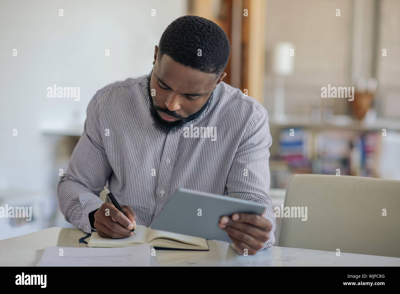Junge afrikanische amerikanische Mann mit einem digitalen Tablette zu Hause Stockfoto