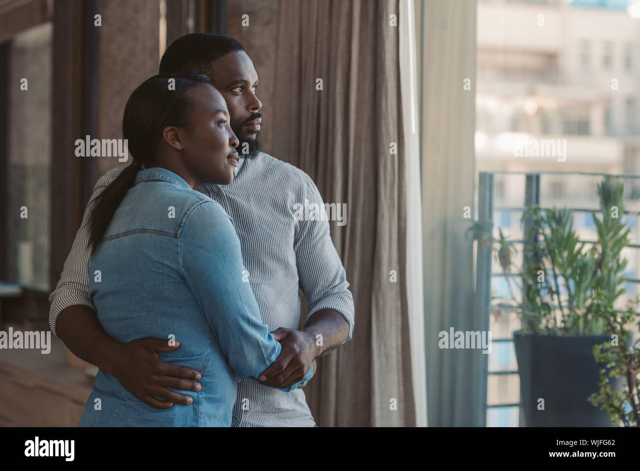 Liebevolle junge afrikanische amerikanische Paar durch ein Fenster Stockfoto