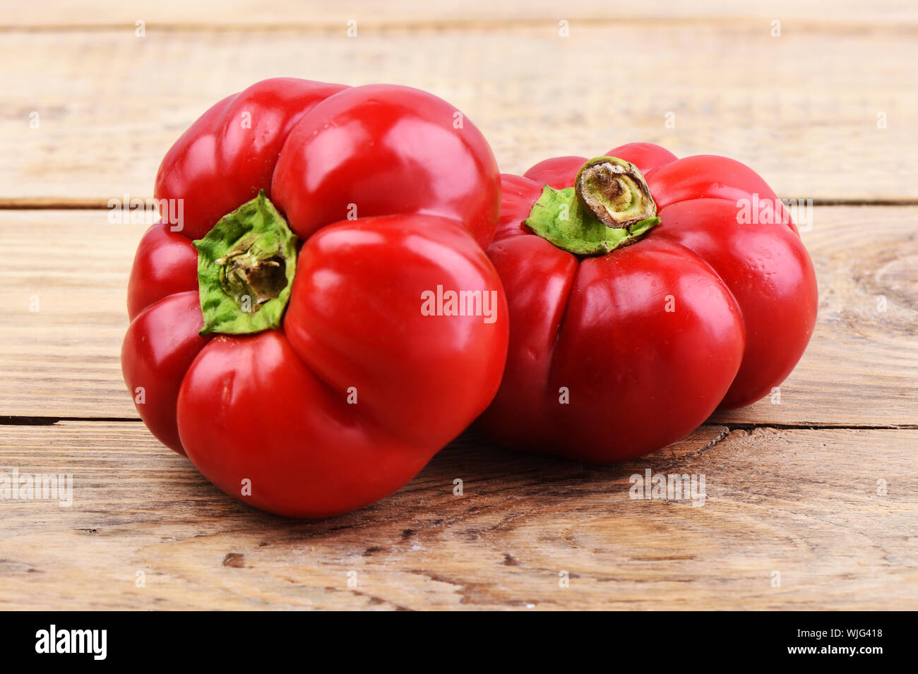 Zwei frische rote Paprika Sorten Gogoshar. Zwei frische rote Paprika über Holz- Tabelle. Im rustikalen Stil. Close Up. Stockfoto