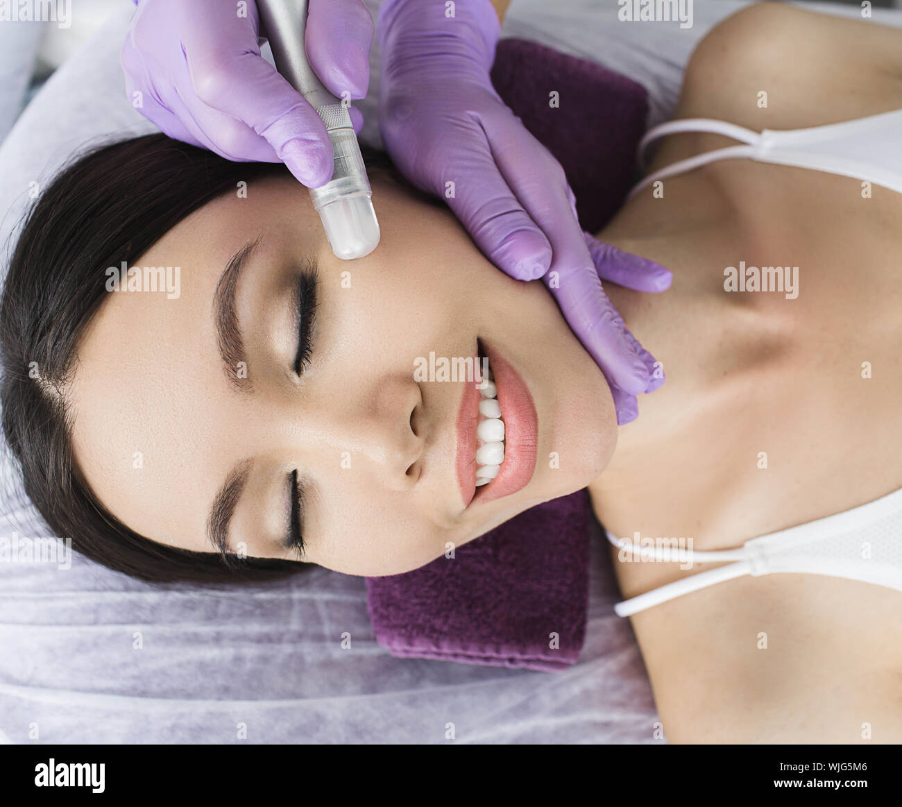 Nette koreanische Frau erhält ein Gesicht peeling Verfahren in einem Schönheitssalon. Hautpflege Stockfoto