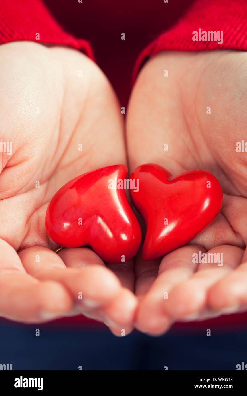 Rote Herzen in Händen - St. Valentin-Konzept Stockfoto