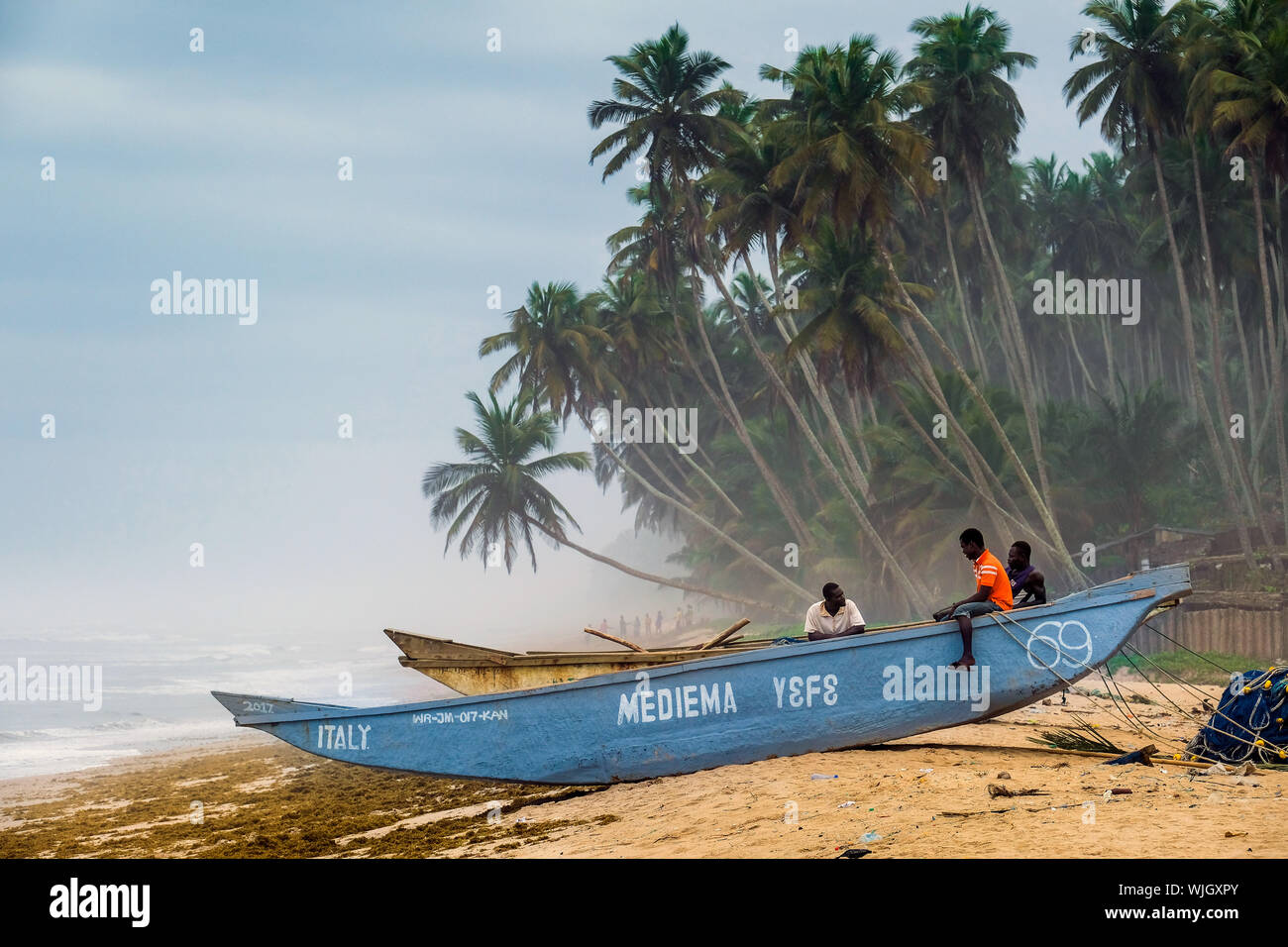 Fischer auf einem Fischerboot am Strand von ländlichen Fischerdorf Kengen, Ghana, Westafrika Stockfoto
