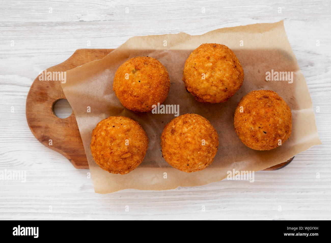 Hausgemachte fried Arancini auf einem rustikalen Holzbrett auf weißem ...
