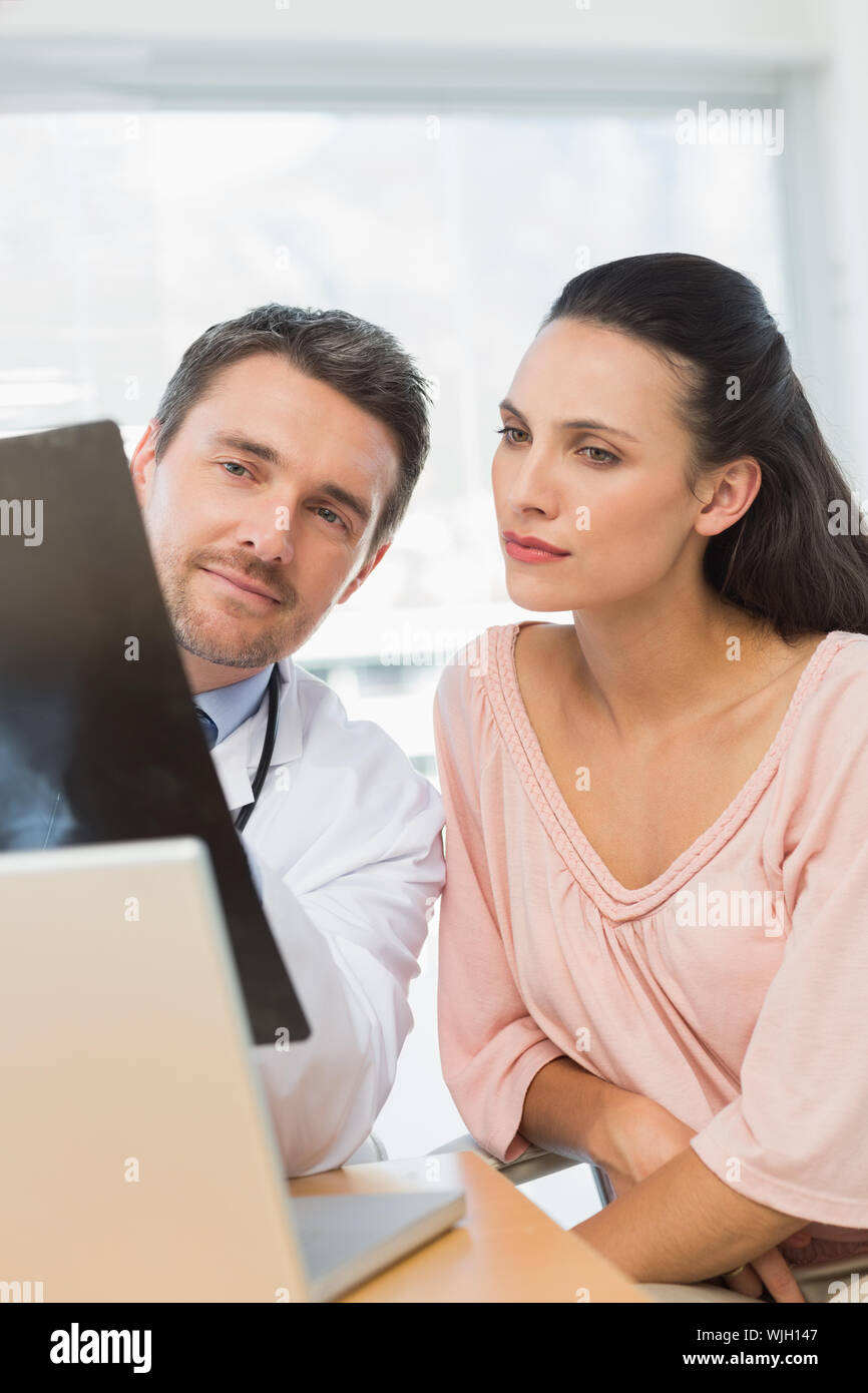Männlicher Arzt erklären, x-ray Bericht für einen Patienten in medizinischen Büro Stockfoto