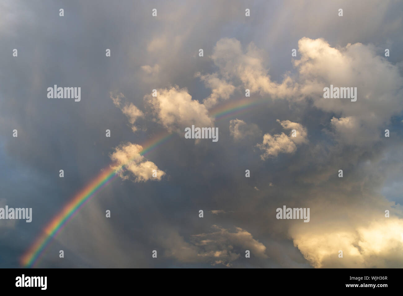 Ein Regenbogen in der stürmischen Himmel, dringt durch die Wolken Stockfoto