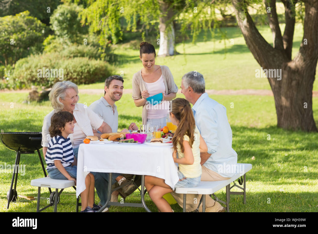 Anzeigen der erweiterten Familie Speisen am Tisch im Freien Stockfoto